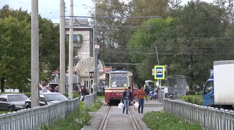 Tram departs from a stop at single-track fenced segregation in Sosnovaya Polyana Stock Footage 67468232