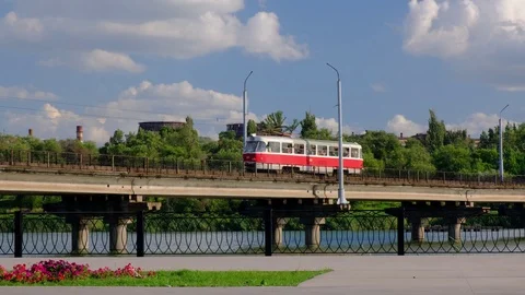 Tram moves along the bridge over the river in a city Stock Footage 112976691