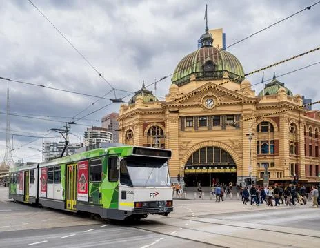 Tram moving at the front of the iconic Flinders Street Station Stock Photos