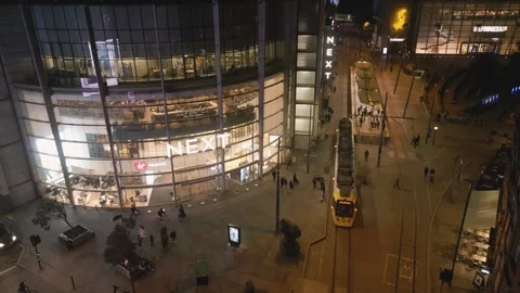 Tram passes NEXT store and Selfridges, Manchester city center, England Stock Footage 257556328