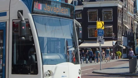 Tram Passing Busy Amsterdam Intersection With Cyclists and Pedestrians Stock Footage 318502189