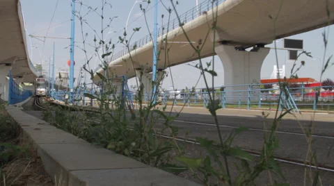 Tram Passing By Under A Big Bridge In The Middle Of The City Stock Footage 63161835