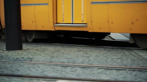 Tram passing with wheels visible in motion on city tracks, capturing public Stock Footage 326067361