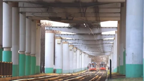 Tram pulls up to a stop under the bridge Stock Footage 69167760