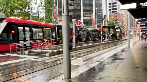 Tram reaching Bridge St stop on a rainy evening at rush hour. Stock Footage 145399945