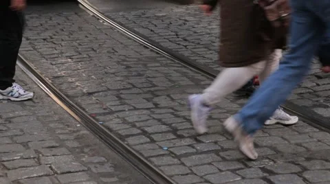 Tram tracks in cobble stone road with people walking across Stock Footage 44871105