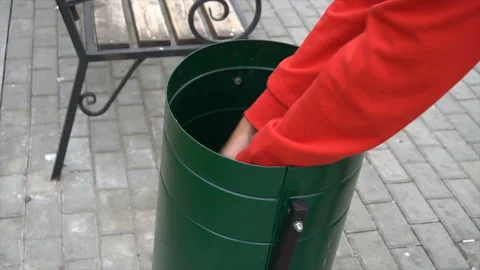 The tramp is digging in the trash can in the park Stock Footage 95215130