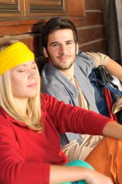 Tramping young couple backpack relax by cottage Stock Photos
