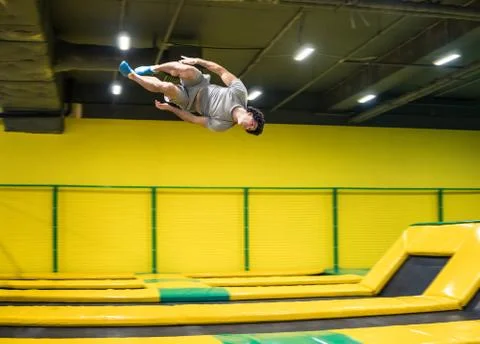 Trampoline jumper performs acrobatic exercises on the trampoline Stock Photos
