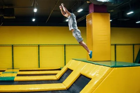 Trampoline jumper performs acrobatic exercises on the trampoline Stock Photos