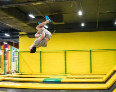 Trampoline jumper performs acrobatic exercises on the trampoline Stock Photos