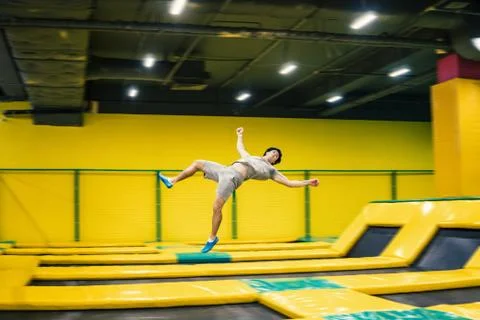 Trampoline jumper performs acrobatic exercises on the trampoline Stock Photos