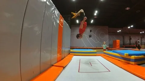 Trampoline Wall Jumping Backflip Practiced by Young Man Slow Motion Video stock 102219972