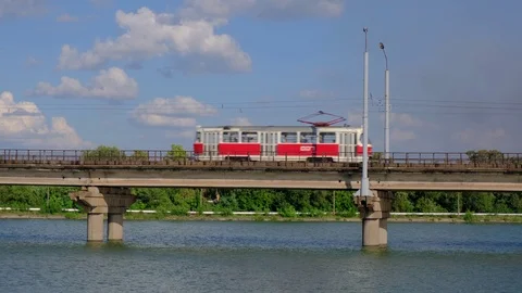 Tramway moves along the bridge over the river in a city Stock-Footage 112977022