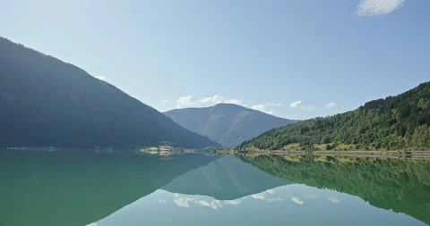 Tranquil azure surface of lake seamlessly reflects lofty mountain summits under Stock-Footage 321319764
