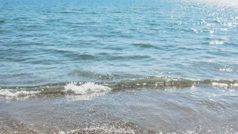 Tranquil background loop featuring the edge of the ocean on a bright, sunny 스톡 동영상 320215972
