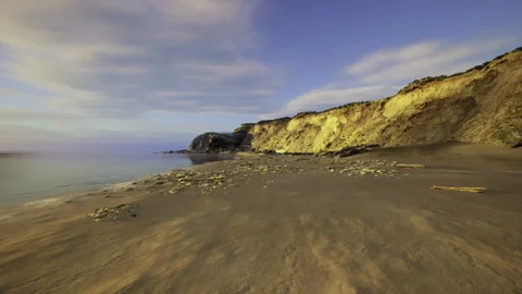 Tranquil beach at dusk with drifting clouds and smooth waters Stock Footage 341817236