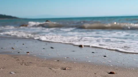 A Tranquil Beach Featuring Gentle Sea Waves and Colorful Seashells Along the 스톡 동영상 312522485