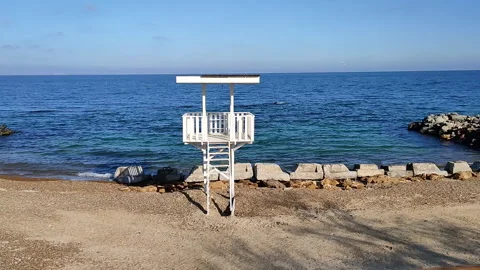 Tranquil beach scene with an empty lifeguard tower by the sea Stock Footage 282242942