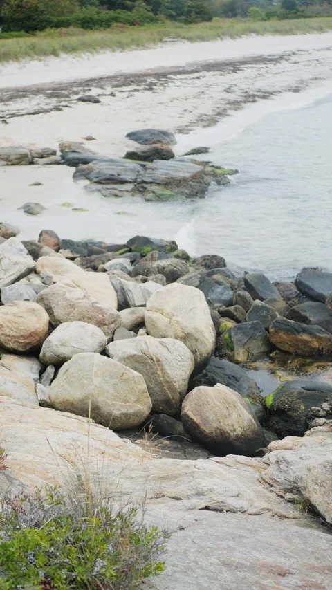 A tranquil beach scene features smooth boulders and rocks... Stock Footage 317702977