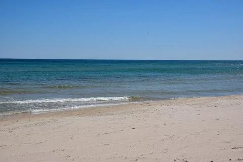Tranquil beach scene with gentle waves and clear blue sky Фото