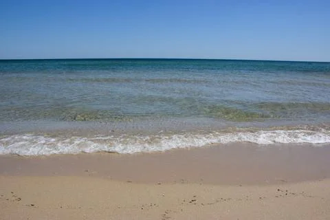 Tranquil beach scene with gentle waves lapping at sandy shore Фото