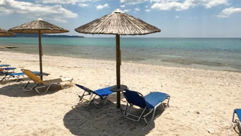 Tranquil Beach With Straw Umbrellas, Lounge Chairs, And Turquoise Sea Stock Footage 304657005