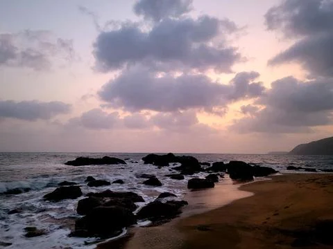 Tranquil Beach Sunset with Dramatic Clouds Stock Photos