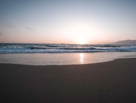 Tranquil Beach Sunset with Gentle Ocean Waves Stock Photos