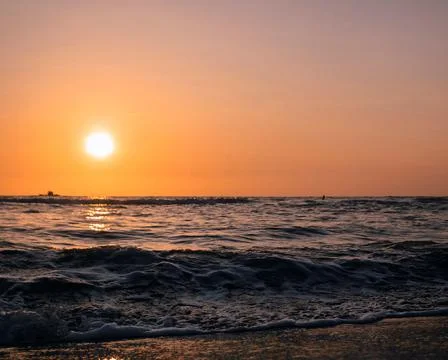 Tranquil Beach Sunset with Gentle Ocean Waves Stock Photos