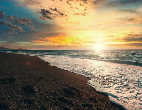 Tranquil Beach Sunset with Gentle Ocean Waves Stock Photos