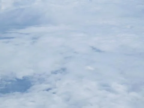 Tranquil Beautiful View From Plane Window at Blue Sky over White Clouds Stock Photos