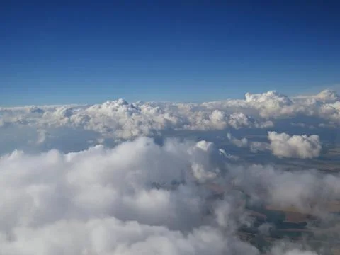 Tranquil Beautiful View From Plane Window at Blue Sky over White Clouds Stock Photos