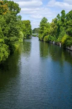 Tranquil canal lined with trees. Stock Photos