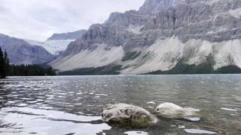 Tranquil Clear water of Bow Lake and crowfoot glacier and mountains in Banff Stock Footage 296320580
