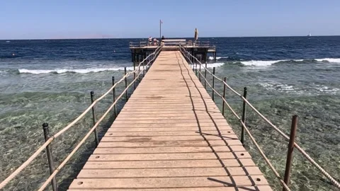 Tranquil Coastal Pier Overlooking Clear Waters: A Scenic Pathway to Serenity 库存影片 330101102