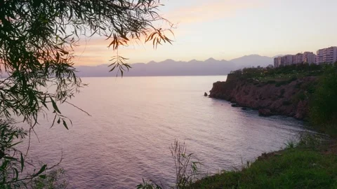 Tranquil coastal setting featuring natural beauty and urban background 스톡 동영상 331556914