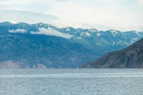 Tranquil coastal view of mountain range and calm blue sea Stock Photos