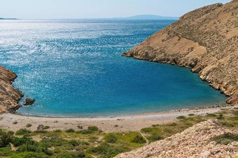 Tranquil cove with pristine waters and rocky landscape. Hiking trail near B.. Stock Photos