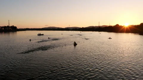 A tranquil dawn view of Ironman swimmers and boats on the Tennessee River, with Stock Footage 320043660
