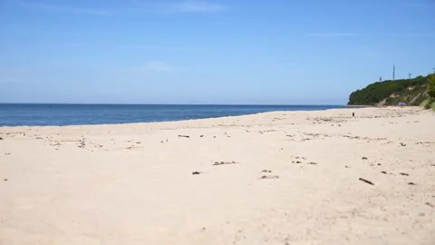 Tranquil empty sandy sea beach under clear blue sky with distant green clif.. Stock Footage 337481473