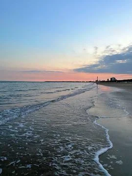 Tranquil Evening at the Beach With Gentle Waves and Colorful Sunset Skies Stock Photos