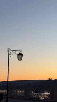 Tranquil evening sky with crescent moon over a city bridge featuring vintag.. Stock Photos