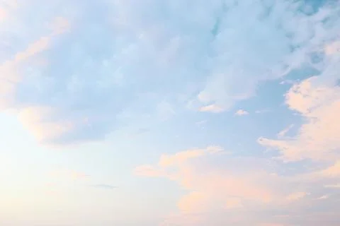 A tranquil evening sky filled with soft pastel colors showcases fluffy clouds Stock Photos