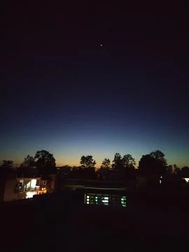 Tranquil Evening Skyline with Distant Star and Silhouetted Trees Foto stock