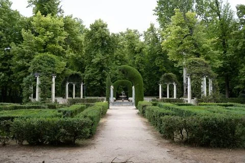 Tranquil garden pathway with classical architecture Stock Photos