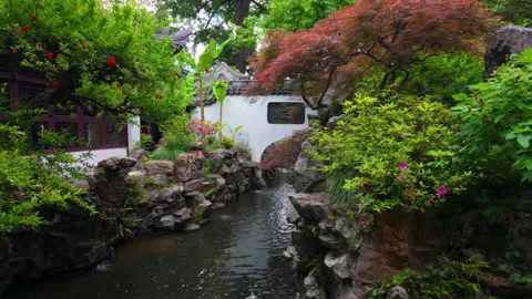Tranquil Garden Pond Surrounded by Lush Trees and Stone Walls in Serene Stockbeeldmateriaal 336769868