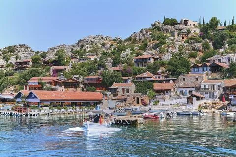 Tranquil harbor scene featuring a mountainous island, majestic castle, docked Stock Photos