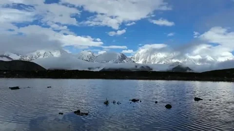 Tranquil High-Altitude Lake Reflecting Snow-capped Peaks in Tibet, China 스톡 동영상 336847423