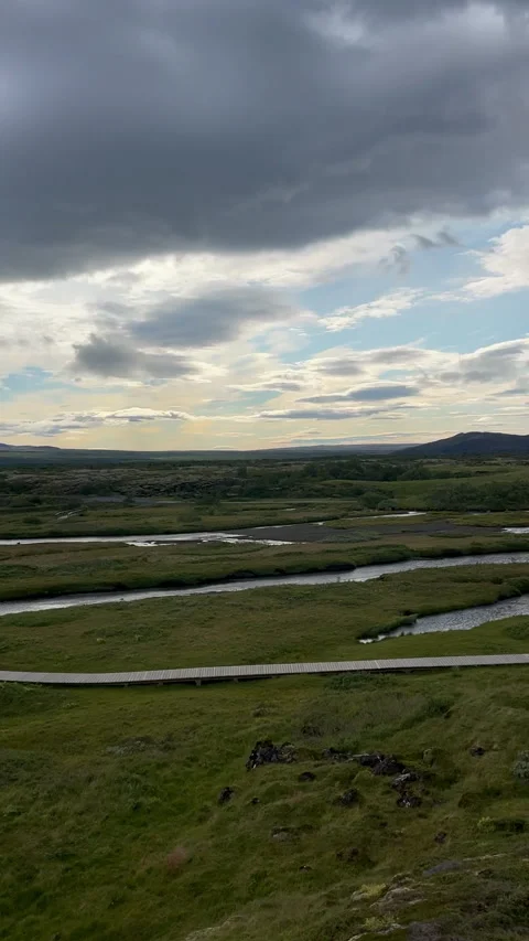 A tranquil Icelandic scene with green fields, rivers, and mountains Stock Footage 312984340